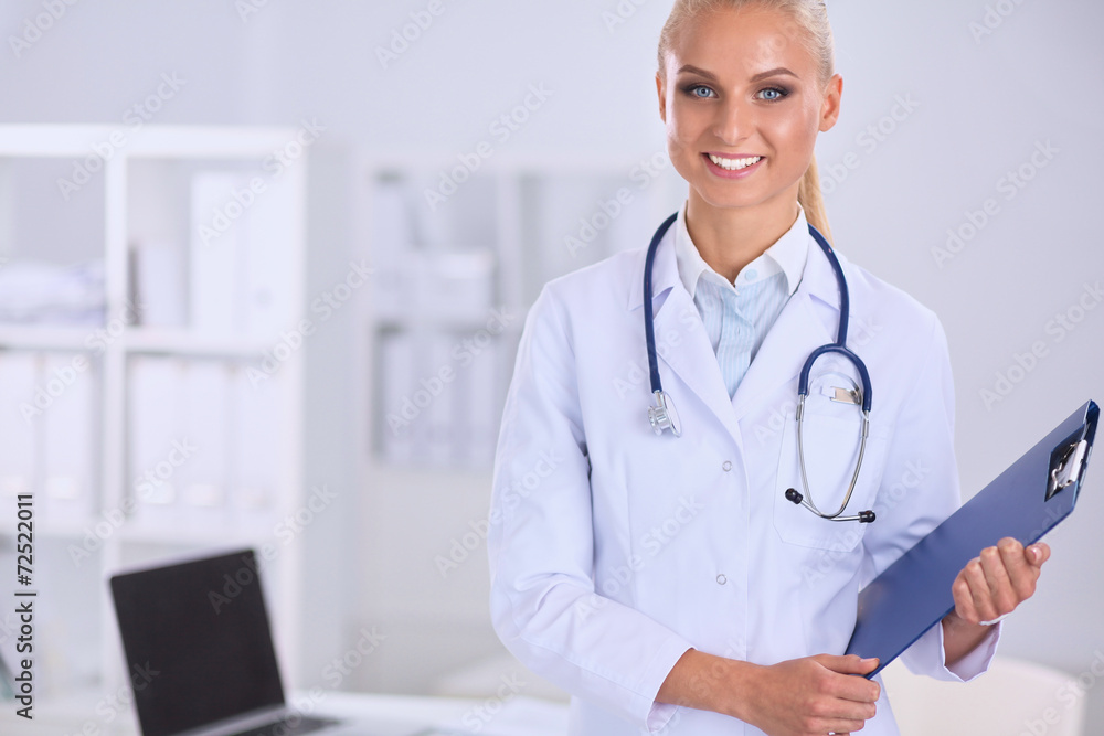 Smiling female doctor with a folder in uniform standing at Smiling female doctor with a folder in uniform standing at