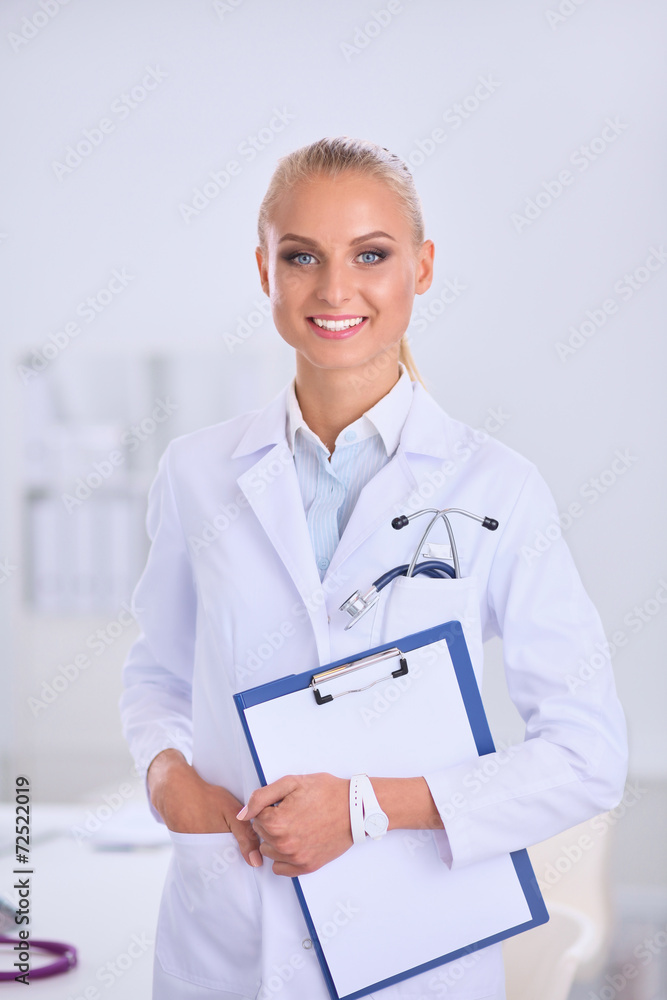 Smiling female doctor with a folder in uniform standing at Smiling female doctor with a folder in uniform standing at