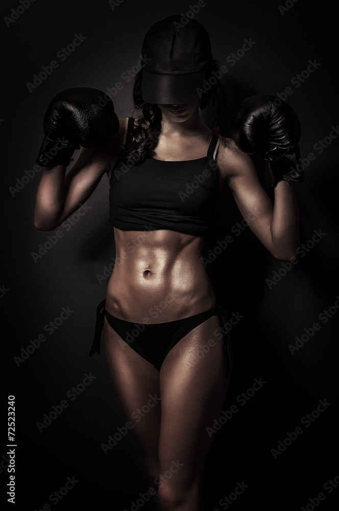 Fit boxing woman in training on black background Fit boxing woman in training on black background