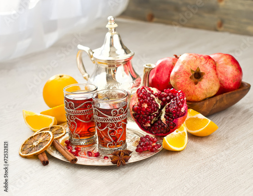 Traditional arabic tea with metal teapot and fruits