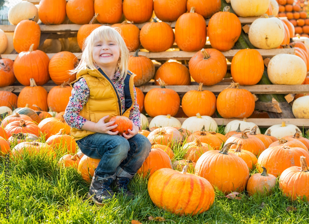 Fototapeta premium Portrait of happy child sitting on pumpkin