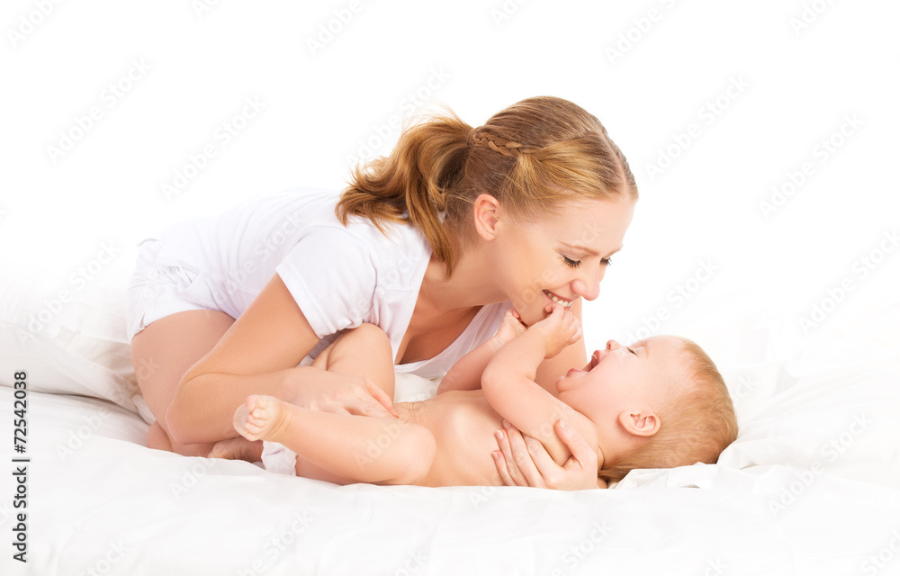 happy family mother and baby having fun playing, laughing on bed happy family mother and baby having fun playing, laughing on bed