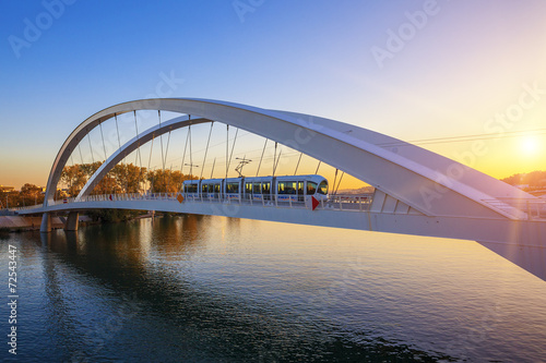 Fototapeta Naklejka Na Ścianę i Meble -  Tramway on the bridge at sunset