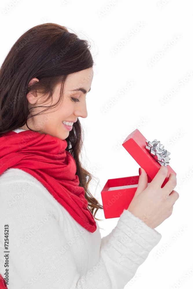 Smiling brunette opening christmas present