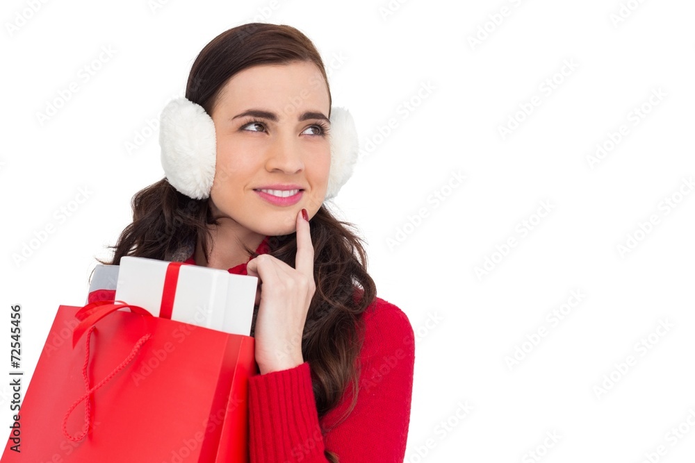 Brunette with ear muffs holding shopping bag full of gifts Brunette with ear muffs holding shopping bag full of gifts