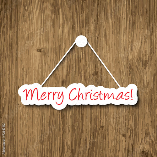 Merry Christmas sign hanging on a wood plank