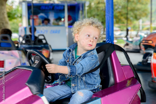 a little boy driving a bumper car
