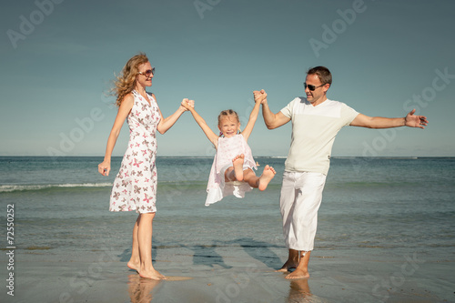 Happy family playing at the beach at the day time