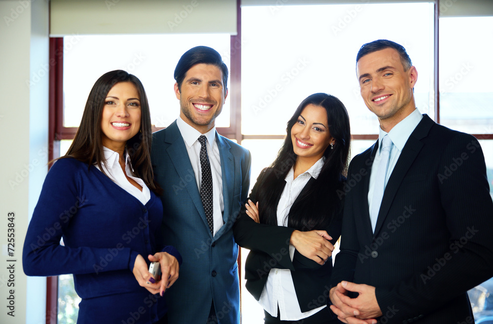 Group of cheerful business people standing in office Group of cheerful business people standing in office