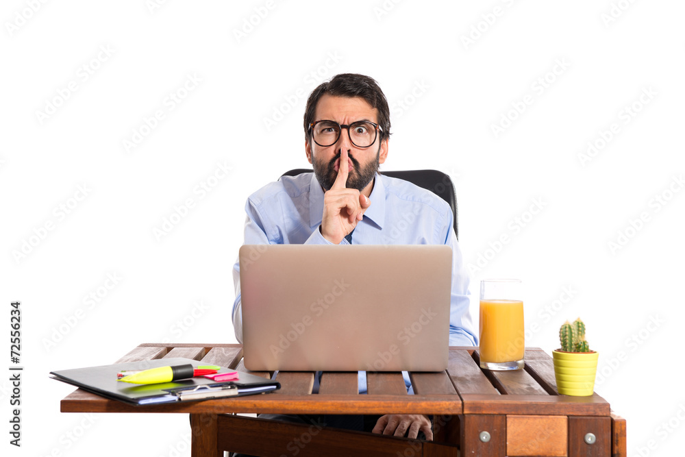Businessman in his office making silence gesture Businessman in his office making silence gesture