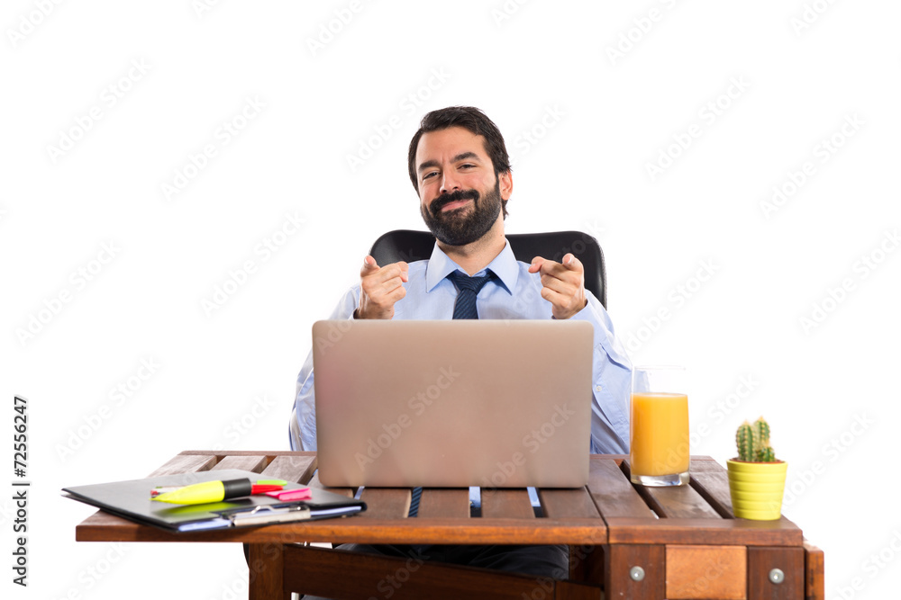 Businessman in his office pointing to the front Businessman in his office pointing to the front