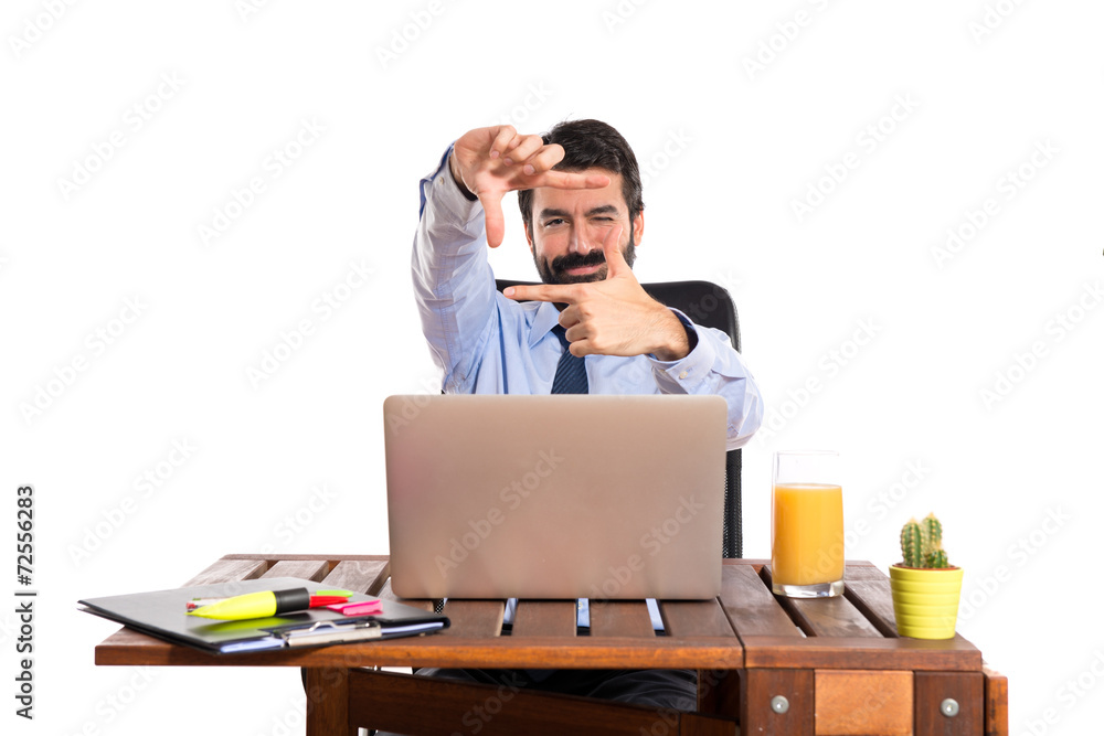 Businessman in his office focusing with his fingers Businessman in his office focusing with his fingers