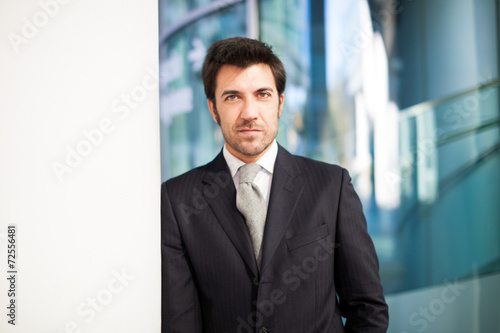 Businessman leaning on a wall