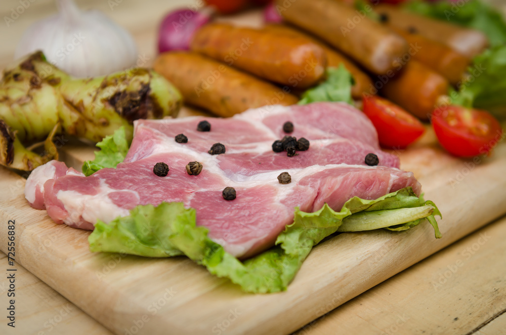 Fresh meat sausages and vegetables on kitchen board Fresh meat sausages and vegetables on kitchen board