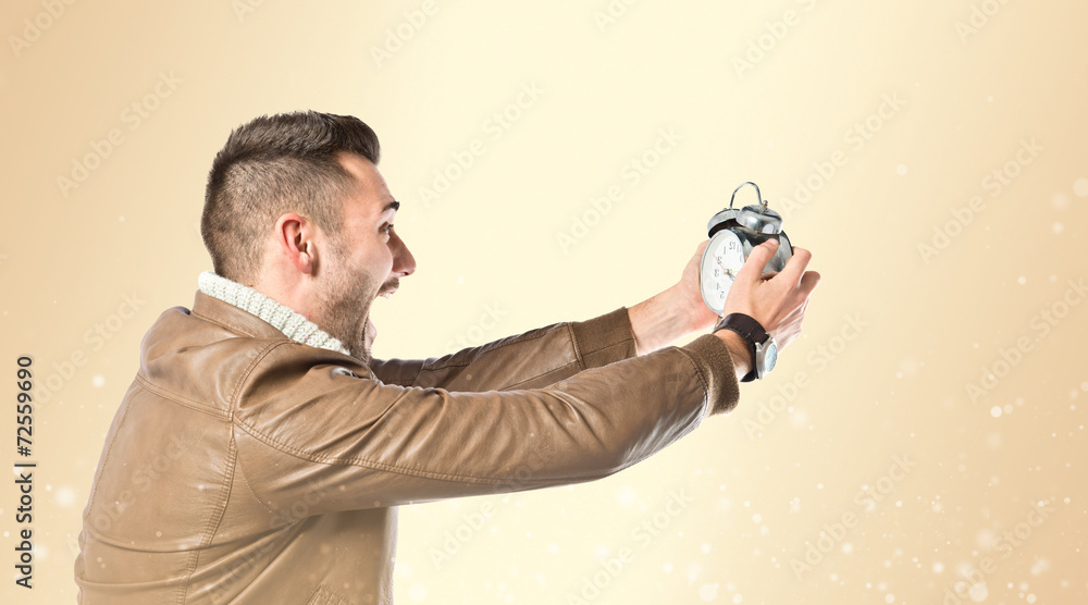 Young businessman holding an antique clock Young businessman holding an antique clock