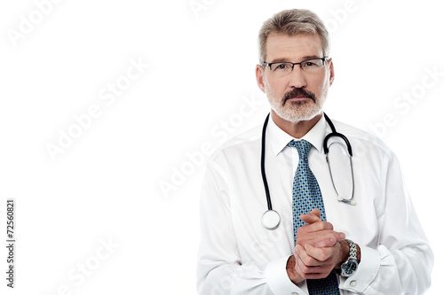 Senior male doctor keeping hands clasped