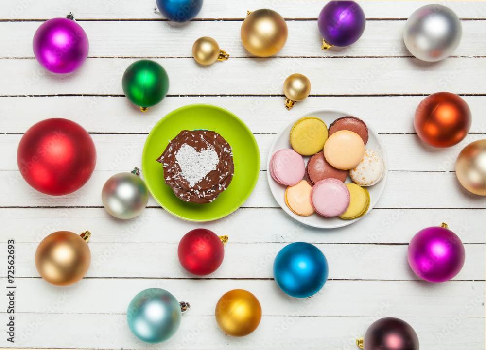 Macaron and cupcake near christmas toys.
