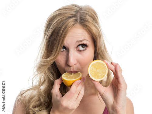 Blonde Frau beisst in eine Zitrone