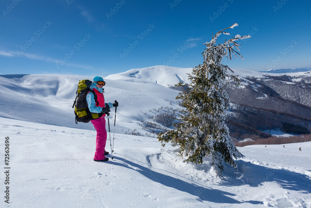 Hiker in winter mountains during sunny day