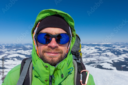 Hiker in winter mountains during sunny day