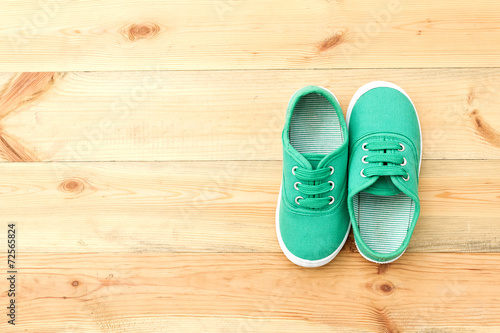 Green shoes on wooden floor.