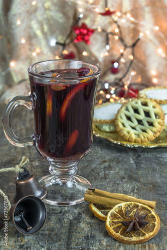 Mulled wine, mince pies and spices on wooden background