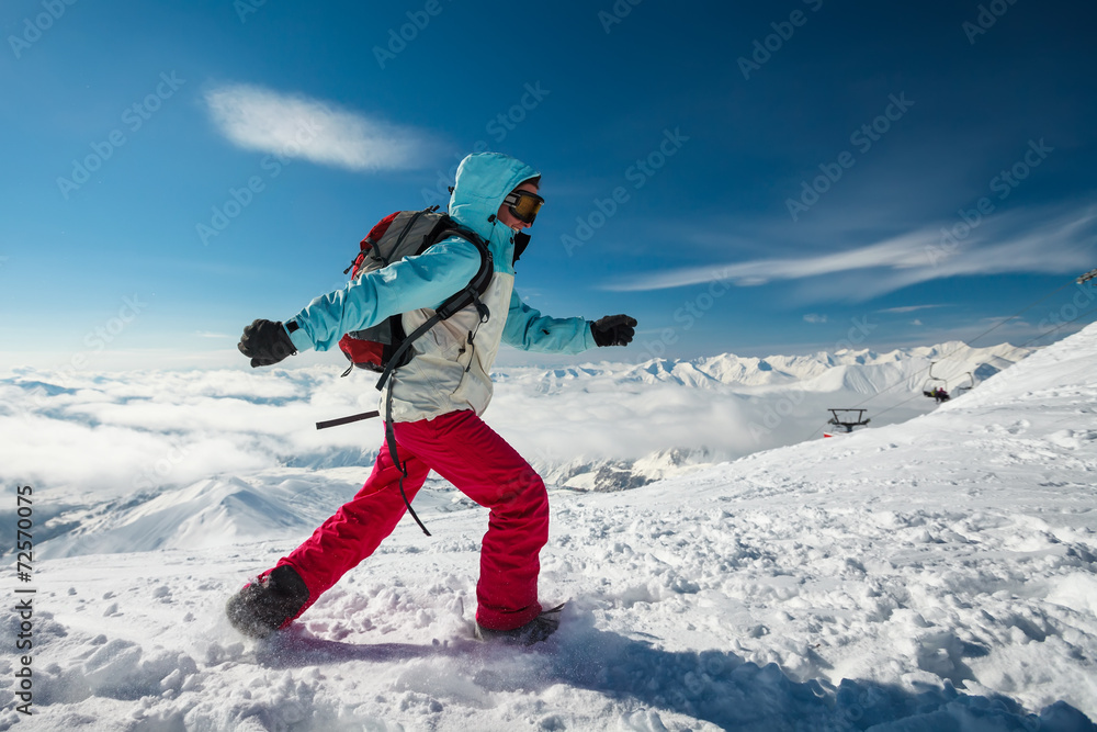 Hiker posing at top of snowy mountain during sunny day Hiker posing at top of snowy mountain during sunny day