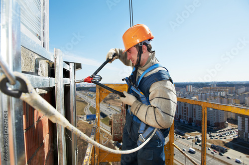 Worker builders at facade tile installation photo