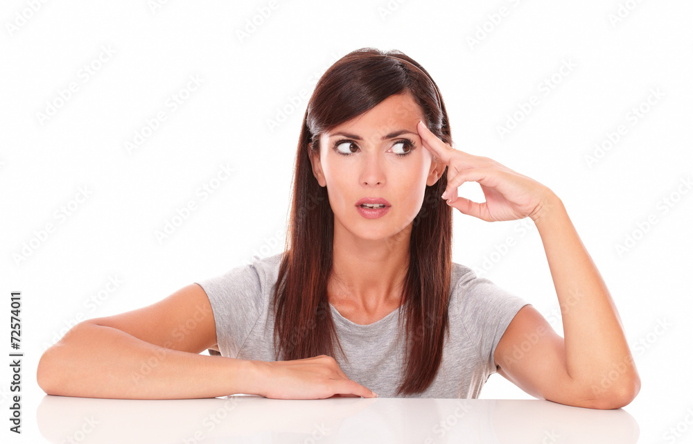 Adult hispanic woman wondering while looking left Adult hispanic woman wondering while looking left