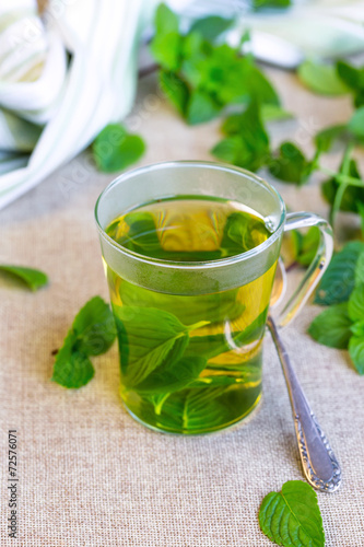 Cup of mint tea with fresh leaves.