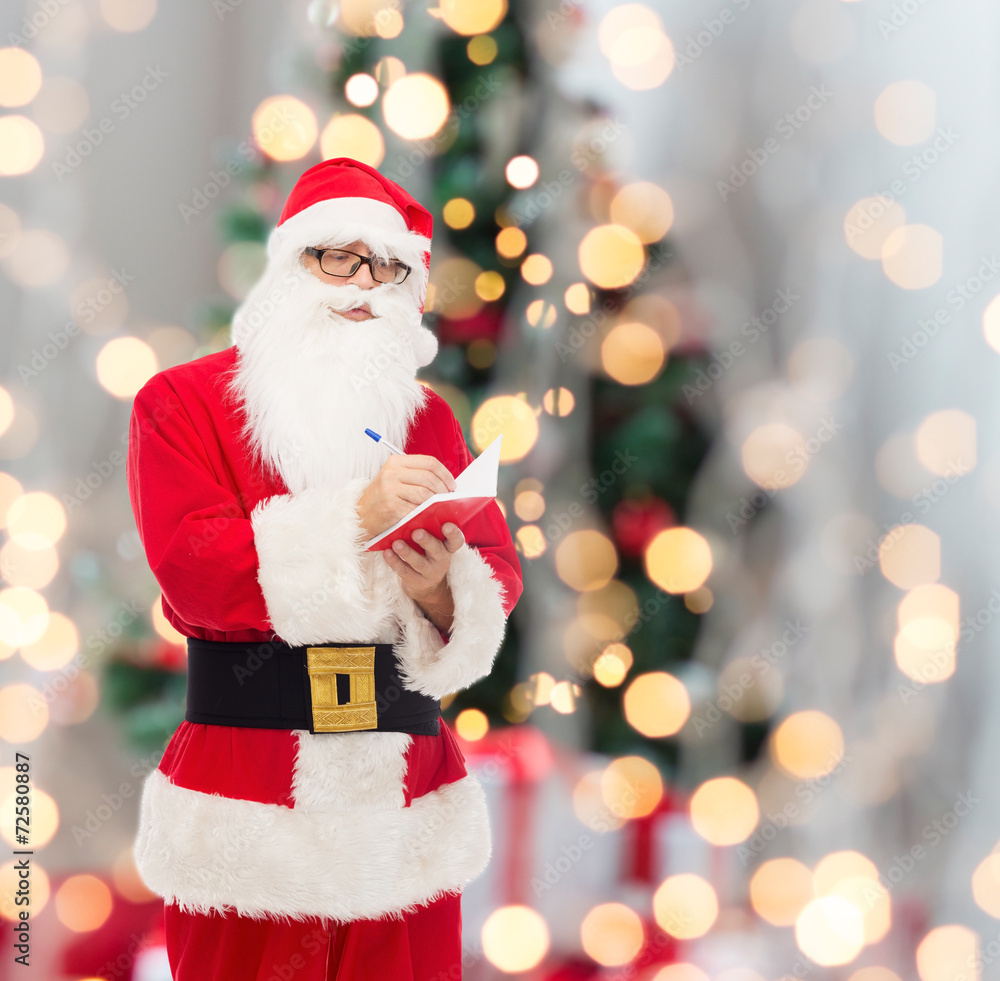 man in costume of santa claus with notepad man in costume of santa claus with notepad