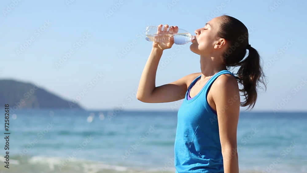 Young smiling woman drinking water after jogging , slow motion Young smiling woman drinking water after jogging , slow motion