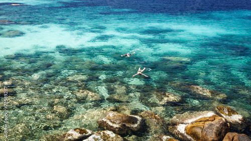 Couple snorkelling in crystal clear sea at tropical island