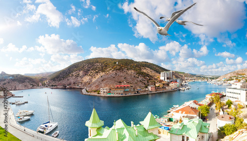 Photos Seagulls fly over Balaklava Bay to the sunny summer day