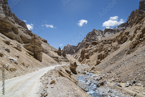mountain road nearby river in jagged rocky mountains © ivan604