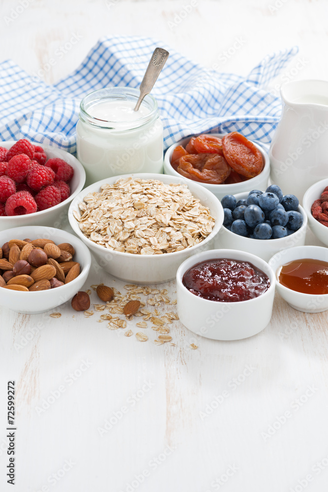 oat flakes and various ingredients for breakfast on white oat flakes and various ingredients for breakfast on white