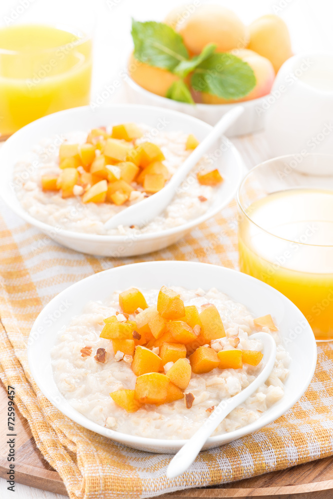 plates of oatmeal with fresh apricots and nuts, orange juice plates of oatmeal with fresh apricots and nuts, orange juice