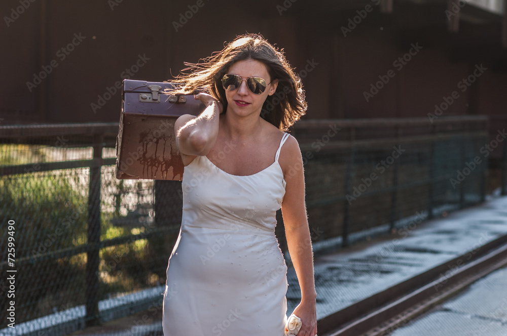 bride on the bridge with her suitcase