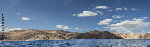Deep blue mountain lake and desert hills panorama