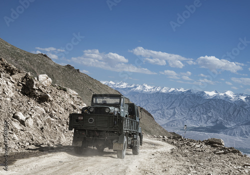 Transportation of army car on truk among mountain landscape