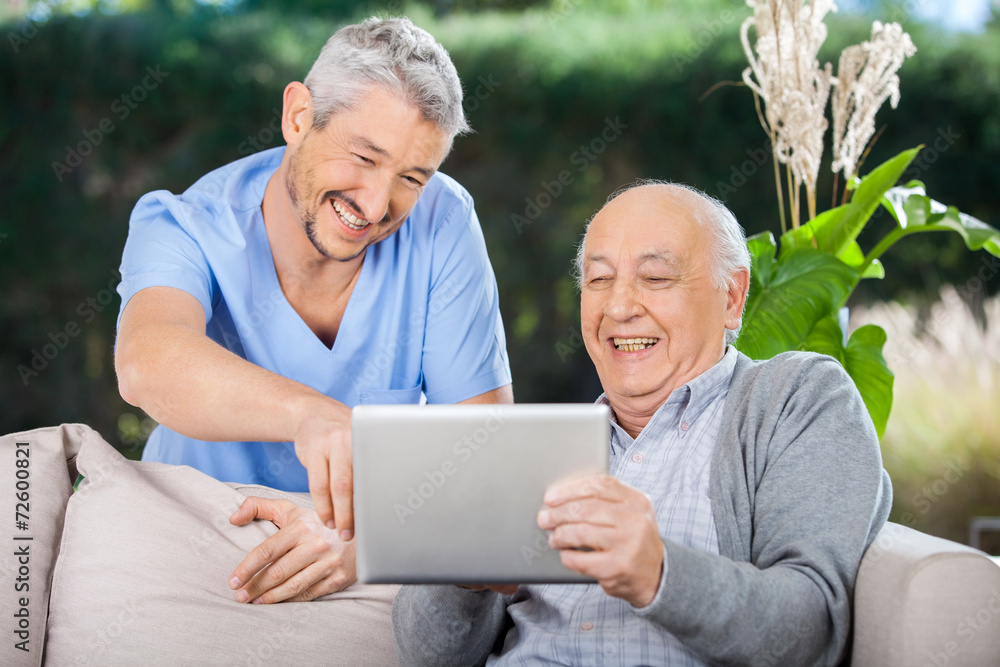 Male Nurse And Senior Man Laughing While Using Digital Tablet Male Nurse And Senior Man Laughing While Using Digital Tablet