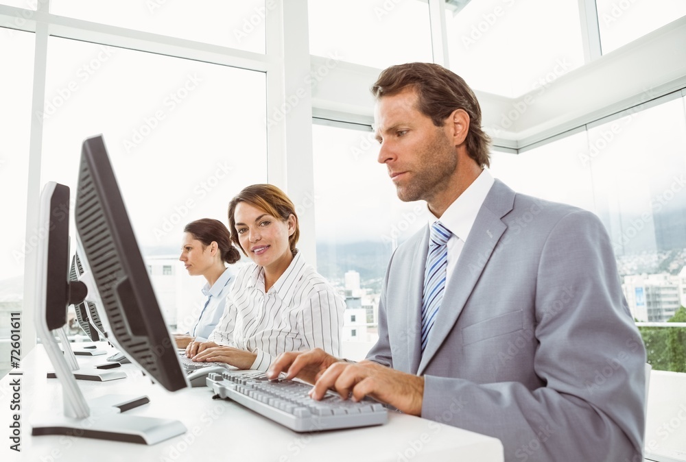 Business people with headsets using computers in office Business people with headsets using computers in office