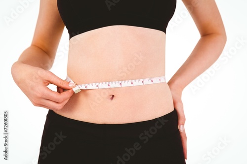 Fit woman measuring her waist