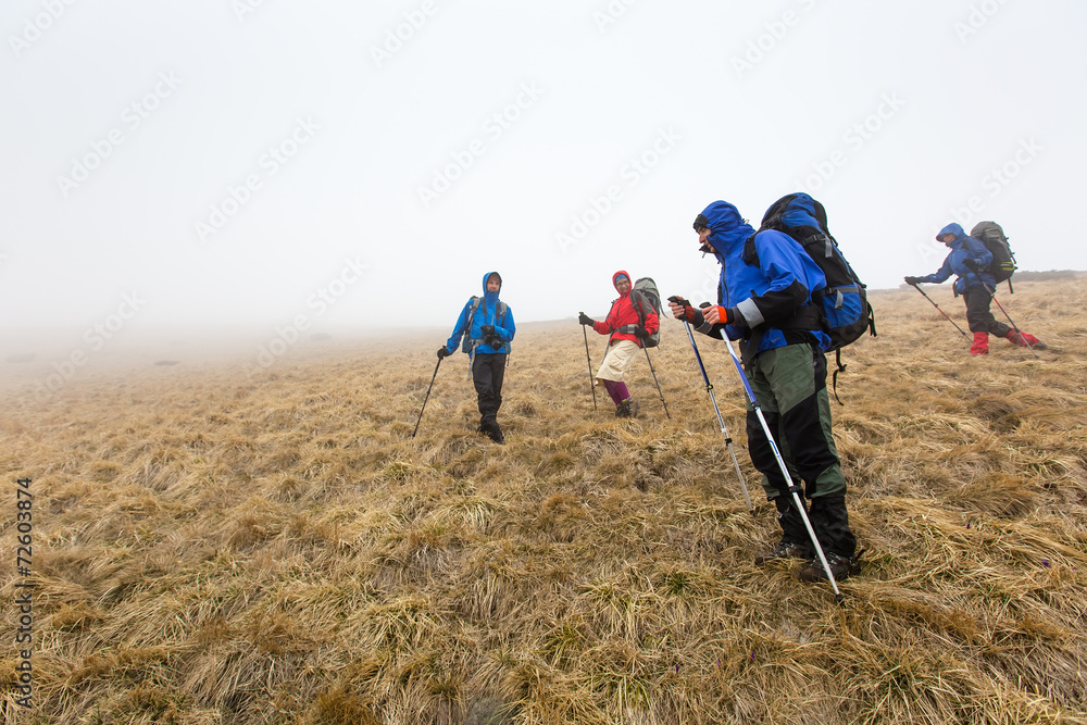 Group of hiker are walking in mountains covered with dense cloud Group of hiker are walking in mountains covered with dense cloud