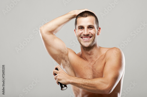 Young muscular man with deodorant