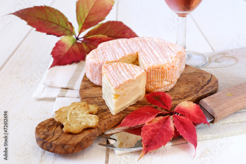 Autumn composition: red leaves, French cheese and wineglass