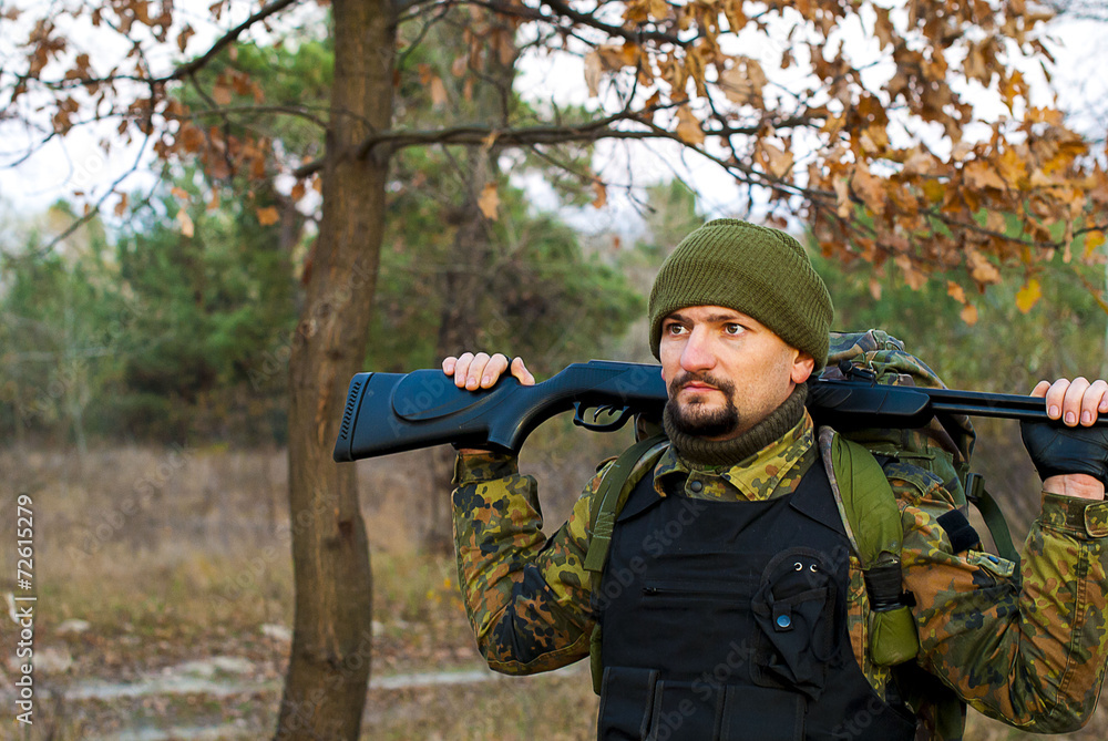 Soldier with a rifle in the autumn forest Soldier with a rifle in the autumn forest