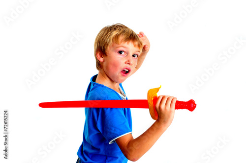 Young boy in studio playing with sword on white background © Seawaters