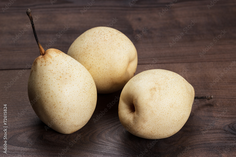 three fresh pears on wooden table three fresh pears on wooden table