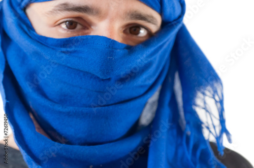 Close up of man wearing blue keffiyeh against white background